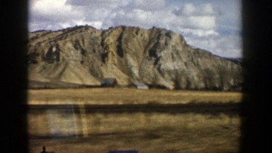 1961: big beautiful brown rocky mountain being recorded by person in a slow