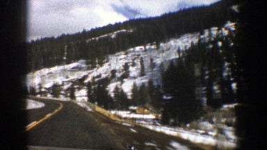 1961: a long road leading around a mounting viewed from the inside of a car