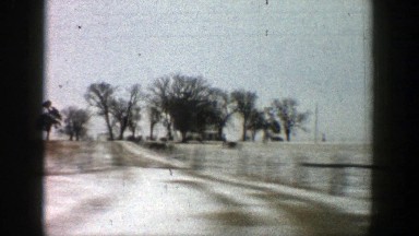 1961: view of farmland from a car window, over the hood and out of the side