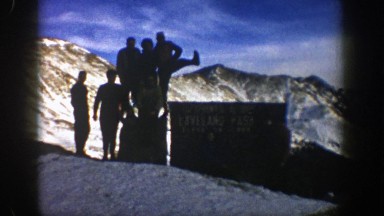 1961: silhouettes of people posing on top of a big mountain in winter ASPEN