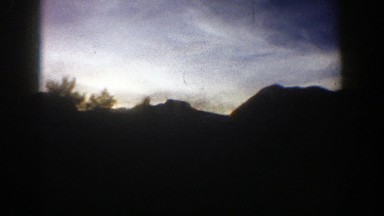 1961: vehicle passing by mountains looking at sunset ASPEN COLORADO