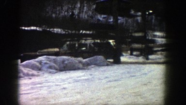 1961: a long sport utility vehicle moving through a road covered under snow