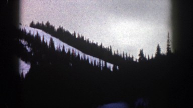 1961: a snowy mountain slope surrounded by evergreen trees in the winter. ASPEN