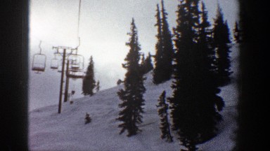 1961: cabins of rope way moving through the wires put up in the icy hills ASPEN
