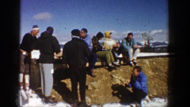 1961: a large group of people sitting on an edge taking a break ASPEN COLORADO