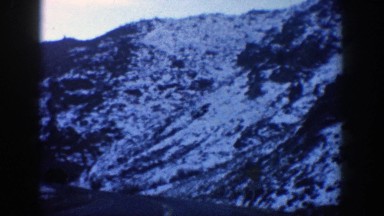 1961: driving on blacktop towards a tunnel with snow on the sides and adjacent