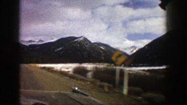 1961: a vehicle drives down a rural road passing through a mountainous area in