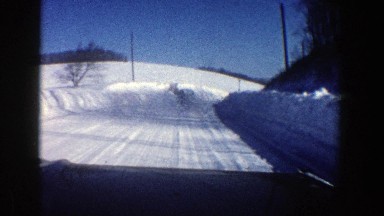 1961: taking a drive around a bend in the road during the winter season. ASPEN