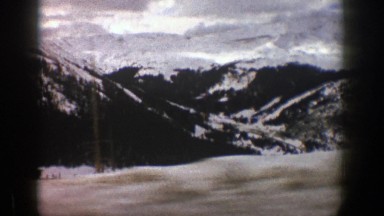 1961: looking outside the window at a snowy, mountainous landscape. ASPEN