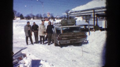 1961: Four Men Beckoning Near a Vehicle in Snowy Aspen, Colorado