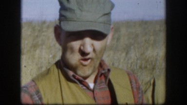 1958: two guys out hunting, standing with guns, one chewing tobacco, one with a