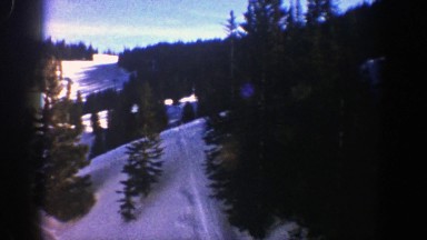 1961: Panorama of Snow-Covered Hills with Skier Tracks and Moving Ski Lift in Aspen, Colorado