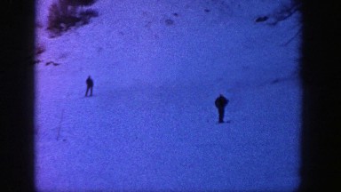 1961: Two People Leisurely Skiing Down a Mountain in Evening Twilight, Aspen