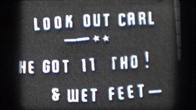 1958: A Sign 'Look Out Carl - He Got It Tho and Wet Feet' and a Fisherman Pulling a Fish