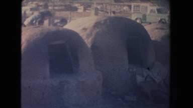 1951: primitive outdoor kilns sit in a barren field next to a busy road NEW