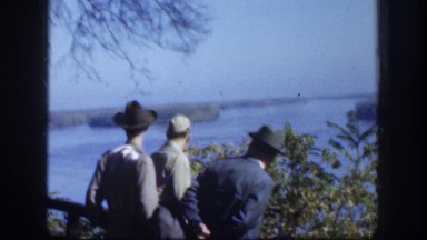 1958: men next to the lake pointing at something. KANSAS