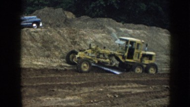 1958: Yellow Tractor Grader Smoothing Dirt in Nebraska