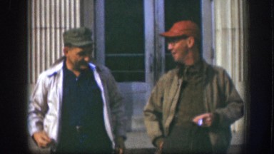1958: Two Male Companions Leaving Building Smiling with Cigarettes Kansas