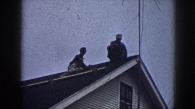 1958: Two Workers Sitting on Roof Changing Clay Tiles