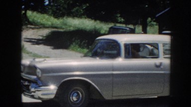 1958: Woman Pulling Vintage Car Out of Parking Space and Driving Off Nebraska