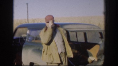 1958: group of men with guns standing near a large building and smiling KANSAS
