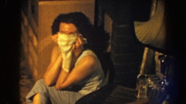 1959: a woman hides her smile behind a handkerchief like a veil NEBRASKA