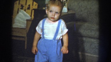 1959: a baby in blue overalls coming toward the camera smiling NEBRASKA
