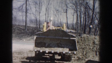 1959: man working on jcb levelling the ground, power of technology developed by