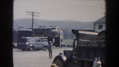1959: train pulling into a station and; a person shoveling dirt into a mound