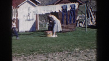 1959: woman putting laundry out to dry on a line with a child NEBRASKA