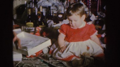 1955: wrapping christmas gifts with playful toddler NEBRASKA