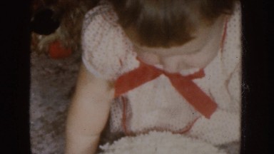 1955: Little Girl Smiling While Watching Cake in Nebraska