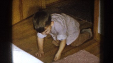1957: family watching young son play on the floor shining shoes. NEBRASKA