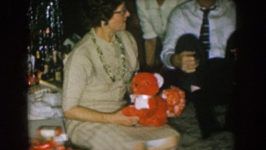 1957: three people sit at the base of a christmas tree next to a pile of