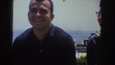 1952: four people smiling, laughing, and looking at the camera on a beach during