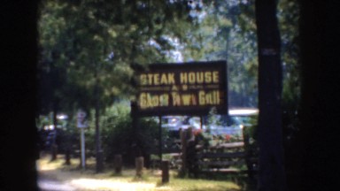 1952: family groups on vacation walk past the entrance of an outdoor restaurant