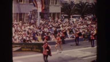 1952: a woman dances in a parade, men march and hold a banner CALIFORNIA