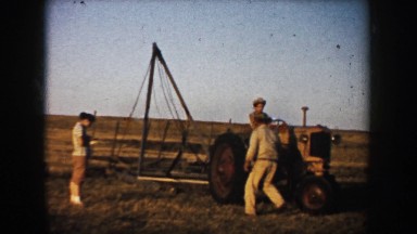 1953: three men with a tractor out in a field with an apparatus SOUTH DAKOTA