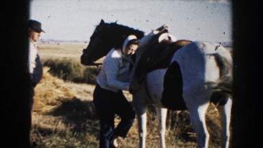 1953: girl climbing on a horse and speaking something. SOUTH DAKOTA