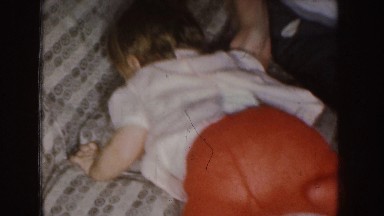 1955: a little child climbing on a sofa and sitting looking around NEBRASKA