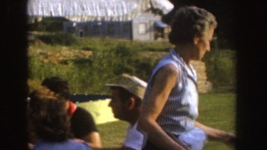 1955: a group of friends or family enjoying a picnic lunch and smoking outdoors