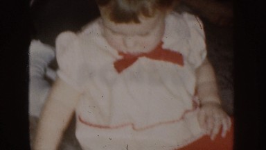 1955: Baby Girl Playing With Toy in Red Dress, Nebraska