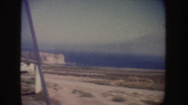 1962: Aged Footage of a Drive Down a Road Through a Desert, California