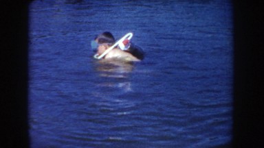 1954: young boy snorkeling in lake, gets water in his goggles SOUTH DAKOTA