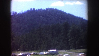 1954: an orange speedboat with three passengers having fun on a blue lake SOUTH