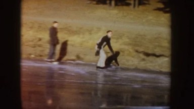 1955: man ice skating and performing tricks on a frozen lake with friends IDAHO