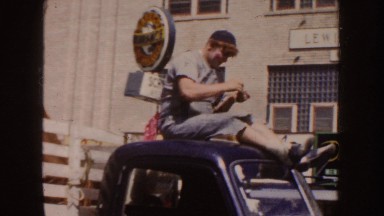 1954: A Man in Black Dress and Cap Crossing a Busy Street in South Dakota