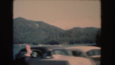 1954: row of parked cars next to a lake where people are swimming SOUTH DAKOTA