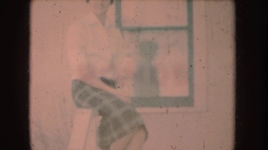 1954: beautiful young lady sitting near to window and standing under a tree
