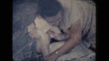 1954: a cute mom wearing specs getting up from the grassy ground SOUTH DAKOTA